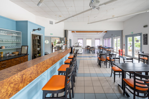 Zona de comedor luminosa y moderna en Camping Seasonova Les Vosges du Nord, en Grand Est, Francia.