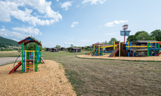 Parque infantil con coloridas estructuras en Camping Seasonova Les Vosges du Nord, Grand Est, Francia.