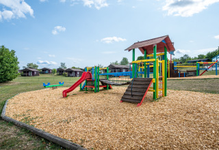 Speelplein met kleurrijk speeltoestel en glijbaan bij Camping Seasonova Les Vosges du Nord in Grand Est, Frankrijk.