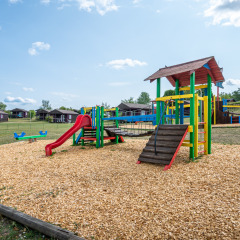 Parque infantil con juegos coloridos y tobogán en Camping Seasonova Les Vosges du Nord en Grand Est, Francia.