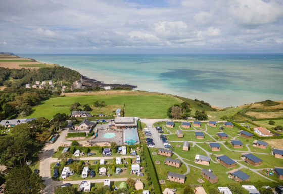 Aerial view of Huttopia Les Falaises holiday park with cabins, campsite, and coastline in Normandy, France.