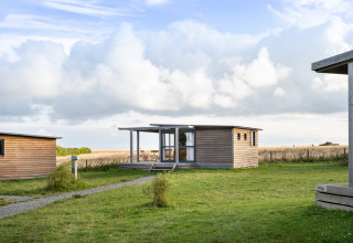 Gezellige houten hut in vakantiepark Huttopia Les Falaises - Normandie, tussen de velden in het Franse landschap.