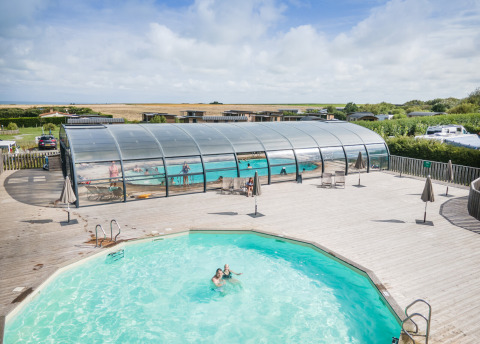 Piscinas exteriores y cubiertas en Huttopia Les Falaises - Normandie, parque vacacional en Normandía, Francia.