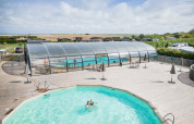 Udendørs og overdækket swimmingpool på Huttopia Les Falaises - Normandie feriepark i smukke Frankrig.