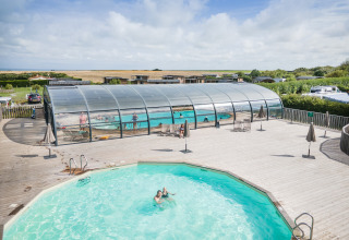 Piscinas exteriores y cubiertas en Huttopia Les Falaises - Normandie, parque vacacional en Normandía, Francia.