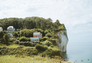 Uitzicht op huizen en bos op de kliffen van Huttopia Les Falaises - Normandie, vakantiepark Frankrijk.