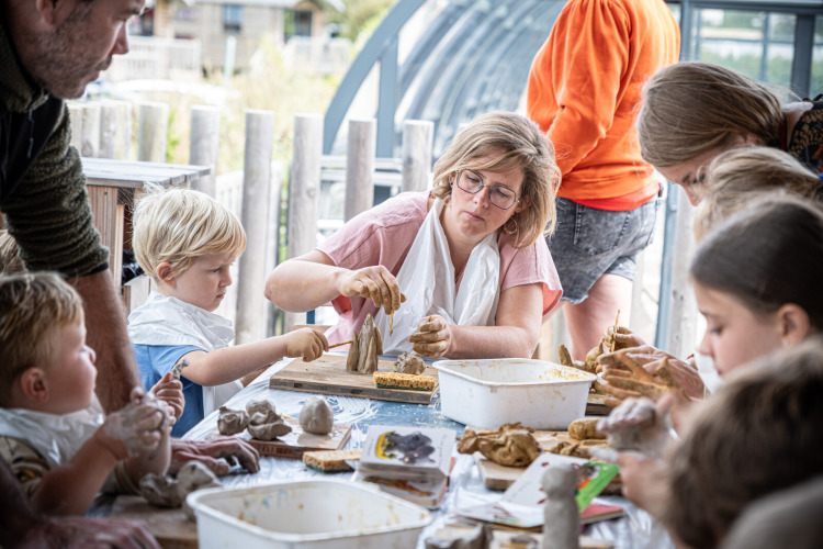 Enfants et adultes réalisent des sculptures en argile à Huttopia Les Falaises - Normandie, parc de vacances.