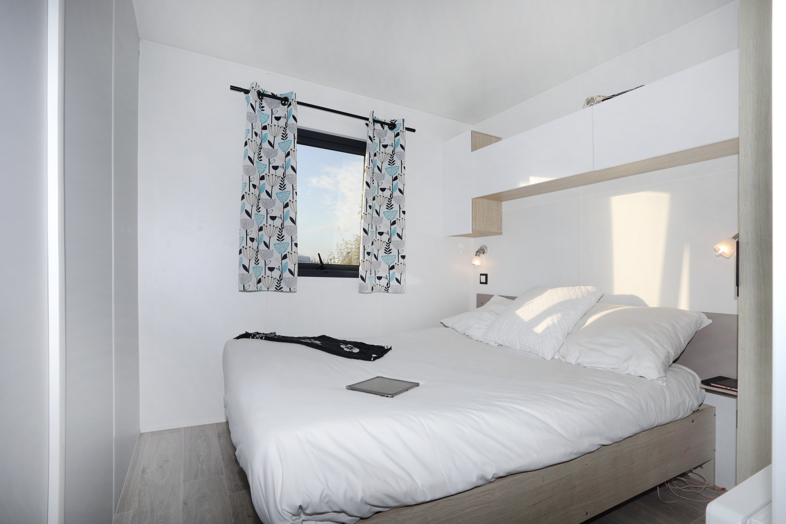 Lichte, moderne slaapkamer in Cottage Prestige bij Camping Seasonova Les 7 Iles in Frankrijk met tweepersoonsbed.