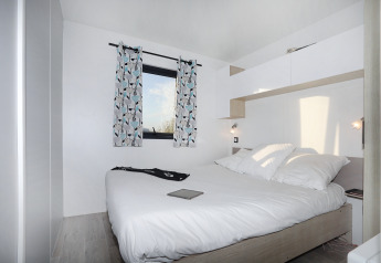 Camera luminosa e moderna del Cottage Prestige al Camping Seasonova Les 7 Iles in Francia, con letto matrimoniale.