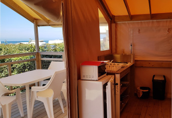 Vista interna di una Eco Lodge al Camping Seasonova Les 7 Iles in Francia, con vista sul mare.
