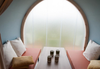 Interior of the Coco Sweet safari tent at Camping Seasonova Les 7 Iles in France, showing seating and mugs.
