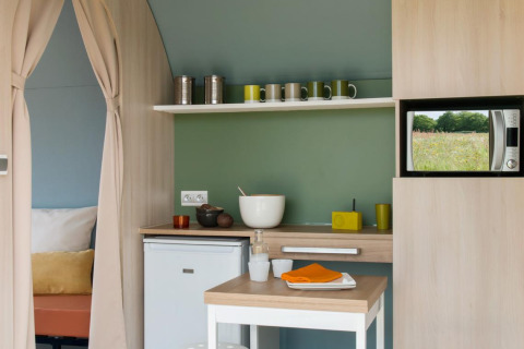 Zona de cocina en una tienda safari Coco Sweet en Camping Seasonova Les 7 Iles, Francia, con microondas.