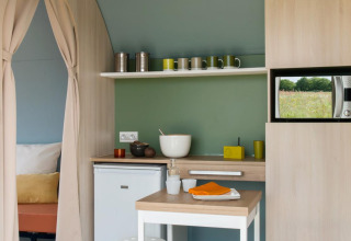 Zona de cocina en una tienda safari Coco Sweet en Camping Seasonova Les 7 Iles, Francia, con microondas.