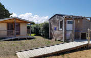 Dos cabañas en Ecolodge Pmr, Camping Seasonova Les 7 Iles en Francia, con rampa y terrazas de madera.