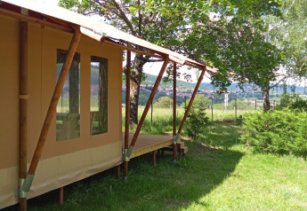 Tienda safari Wood Lodge en Camping Seasonova Les Vosges du Nord en Francia, rodeada de árboles verdes.