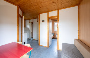 Interno di uno chalet con pannelli in legno al Camping Seasonova Les Vosges du Nord, tavolo e divano.