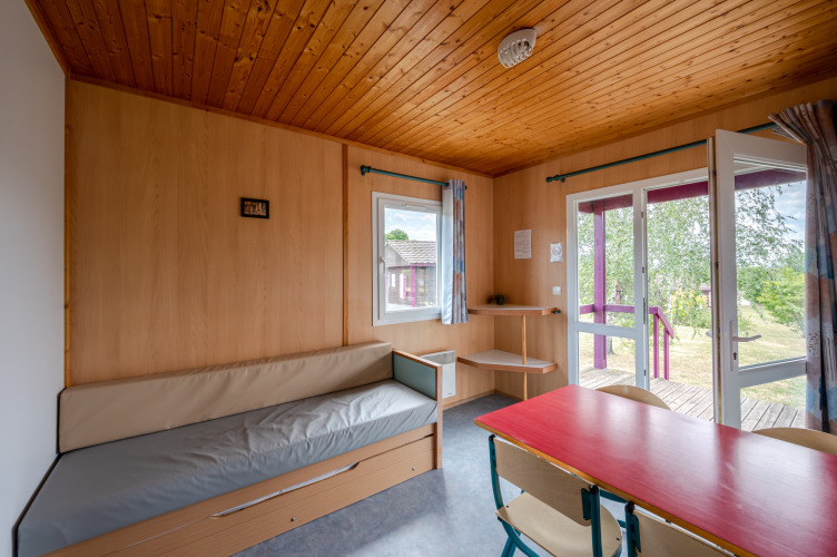 Interieur van Chalet ZEN op Camping Seasonova Les Vosges du Nord met houten afwerking en open deuren.