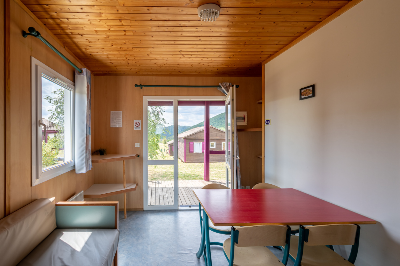 Interieur van Chalet ZEN bij Camping Seasonova Les Vosges du Nord met licht hout en grote ramen.