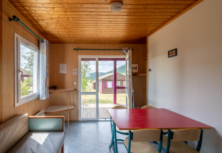 Vista interior del Chalet ZEN en Camping Seasonova Les Vosges du Nord con madera clara y ventanales.