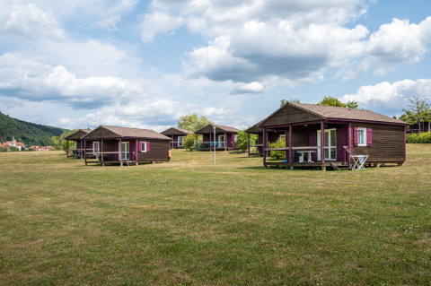 Houten huisjes op een open veld bij Chalet ZEN, Camping Seasonova Les Vosges du Nord, Frankrijk.