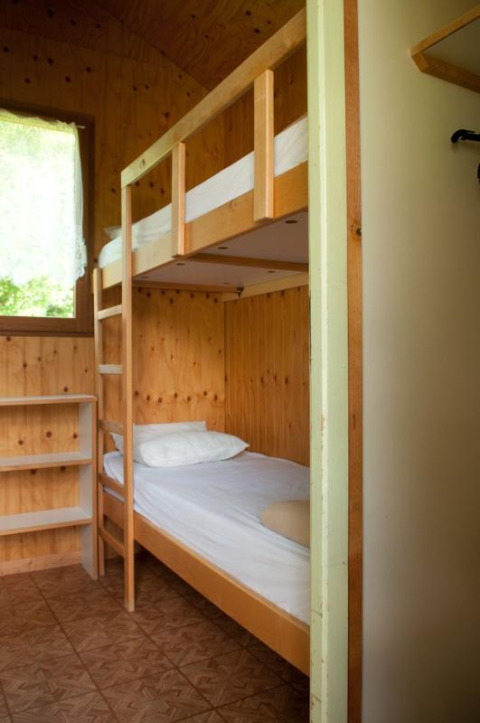 Habitación con litera de madera en Chalet Isabelle, Camping Seasonova Les Vosges du Nord, Francia.