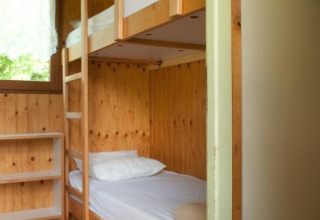 Habitación con litera de madera en Chalet Isabelle, Camping Seasonova Les Vosges du Nord, Francia.
