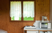 Interieur van Chalet Anaïs bij Camping Seasonova Les Vosges du Nord, Frankrijk, met kitchenette en raam.
