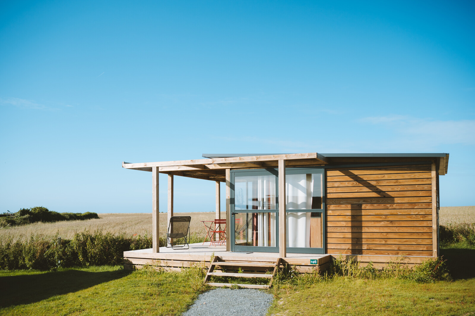 Chalet Evasion Vista bij Huttopia Les Falaises - Normandië, Frankrijk, modern houten chalet in natuur.