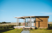 Chalet Evasion Vista bij Huttopia Les Falaises - Normandië, Frankrijk, houten chalet in groene omgeving.