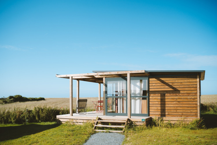 Chalet Evasion Vista en Huttopia Les Falaises - Normandie, Francia, cabaña de madera en entorno natural.