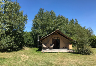 Safarizelt Tente Canadienne bei Huttopia Les Falaises in der Normandie, umgeben von grünen Bäumen und Wiese.