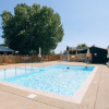 Outdoor swimming pool with sun loungers and umbrellas at Camping Seasonova Ile de Ré, Nouvelle-Aquitaine, France.