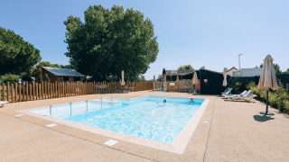 Buitenzwembad met ligstoelen en parasols bij Camping Seasonova Ile de Ré, Nouvelle-Aquitaine, Frankrijk.