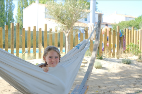 Un bambino si rilassa su un'amaca al Camping Seasonova Ile de Ré, un villaggio vacanze in Nouvelle-Aquitaine, Francia.