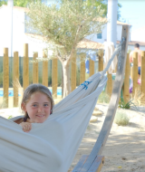 Un niño relajándose en una hamaca en Camping Seasonova Ile de Ré, un camping en Nouvelle-Aquitaine, Francia.