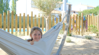 Ein Kind entspannt in einer Hängematte auf dem Campingplatz Seasonova Ile de Ré in Nouvelle-Aquitaine, Frankreich.