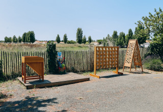 Buitenspeelzone met houten spelletjes op Camping Seasonova Ile de Ré, Nouvelle-Aquitaine, Frankrijk.