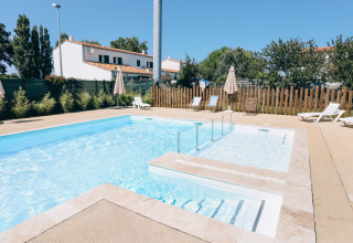 Udendørs swimmingpool med liggestole og parasoller på Camping Seasonova Ile de Ré, Nouvelle-Aquitaine, Frankrig.