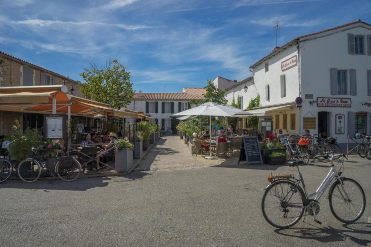 Terrasses de cafés et vélos sous le ciel bleu à Camping Seasonova Ile de Ré, Nouvelle-Aquitaine, France.