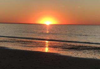 Zonsondergang aan zee nabij Les Portes-en-Ré, Frankrijk, met een oranje horizon en kalme zee.