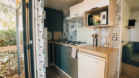 Cocina moderna en una cabaña Cottage Prestique en Camping Seasonova Ile de Ré, Francia, con electrodomésticos.