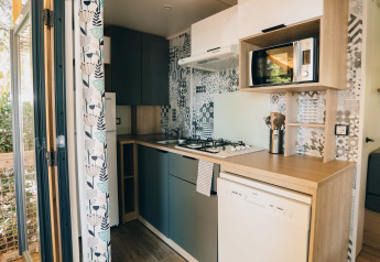 Cocina moderna en una cabaña Cottage Prestique en Camping Seasonova Ile de Ré, Francia, con electrodomésticos.
