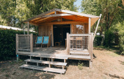 Cabaña de madera Lodge Premium en Camping Seasonova Ile de Ré, Francia, con terraza y tumbonas azules.