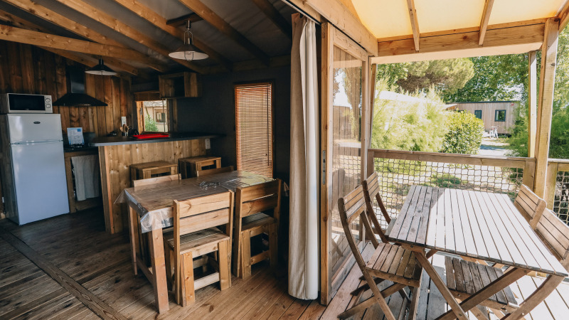 Vista interior y exterior de la cabaña Lodge Premium en Camping Seasonova Ile de Ré en Francia.