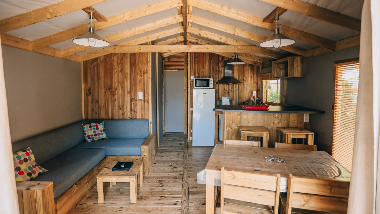 Interieur van Lodge Premium bij Camping Seasonova Île de Ré, Frankrijk, met houten inrichting en moderne gemakken.