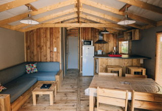 Binnenkant van Lodge Premium hut op Camping Seasonova Île de Ré, Frankrijk, met houten interieur en moderne voorzieningen.