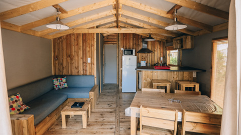 Interior de la cabaña Lodge Premium en Camping Seasonova Ile de Ré, Francia, con decoración de madera y modernas comodidades.