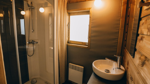 Modernes Badezimmer in der Lodge Premium auf Camping Seasonova Ile de Ré in Frankreich mit Dusche und Waschbecken.
