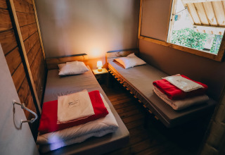 Dos camas individuales en una acogedora cabaña del Lodge Premium, Camping Seasonova Ile de Ré, Francia.