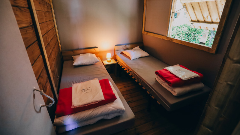 Dos camas individuales en una acogedora cabaña del Lodge Premium, Camping Seasonova Ile de Ré, Francia.